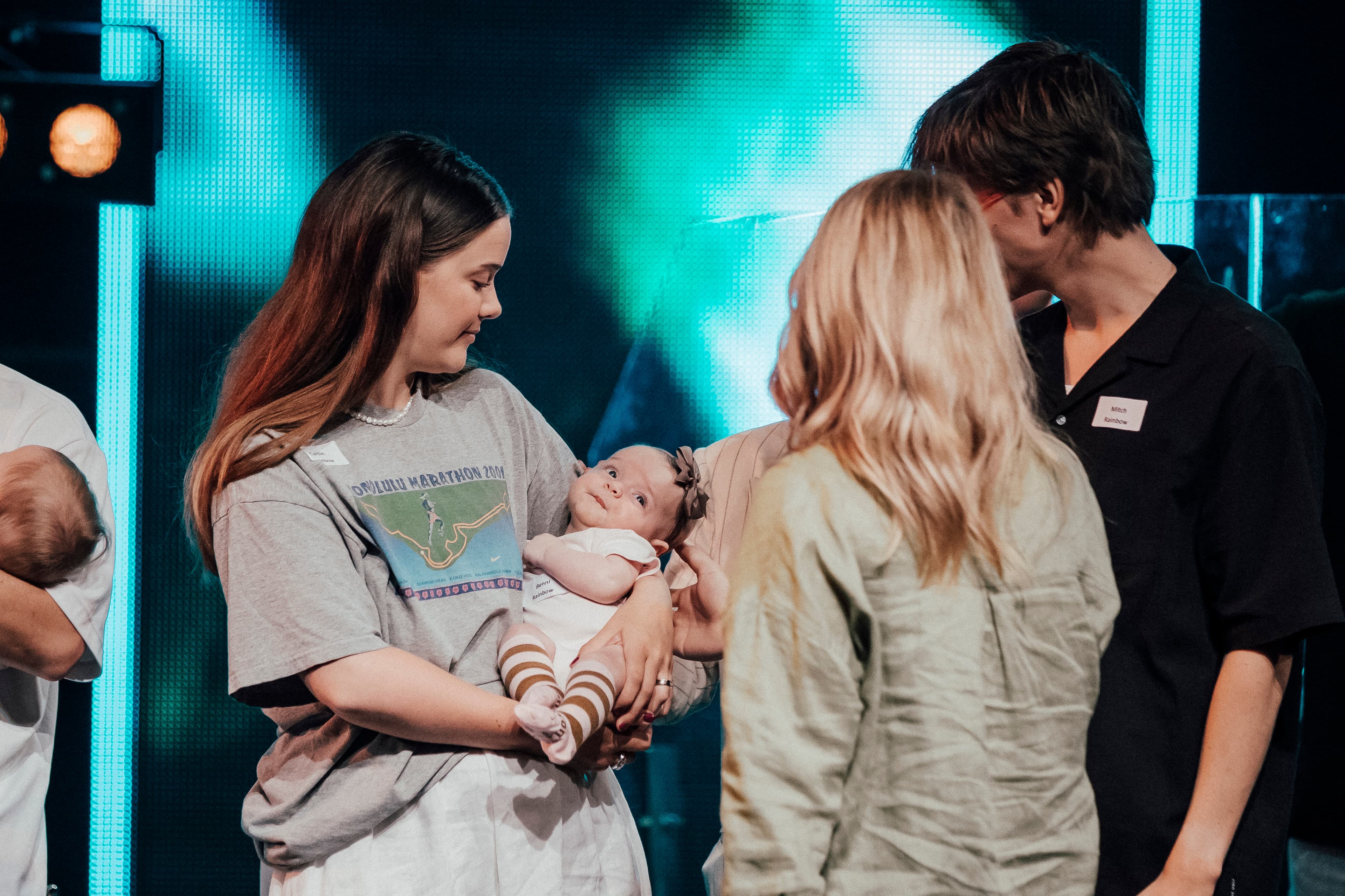 Baby held by her mother and being prayed for by a pastor with her back to the camera at North Campus for Child Dedications