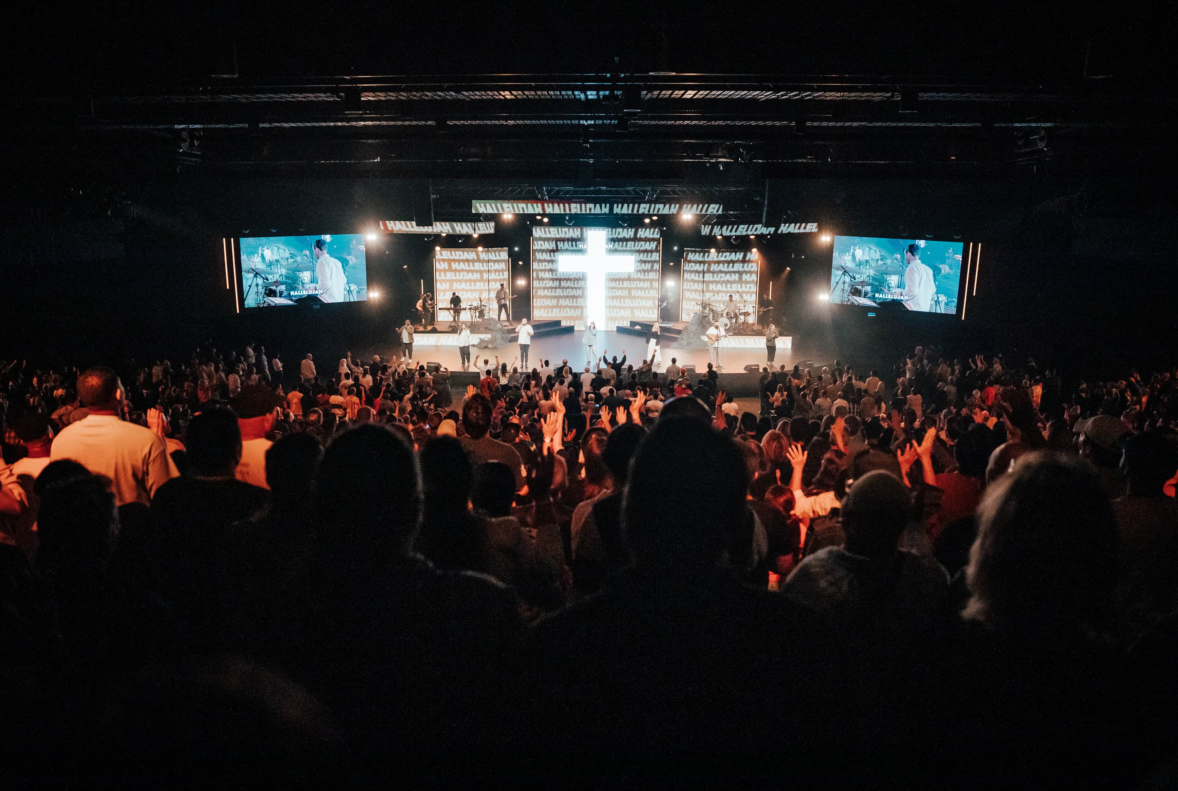 Easter at Central with cross on screen behind worship team looking down from back of auditorium