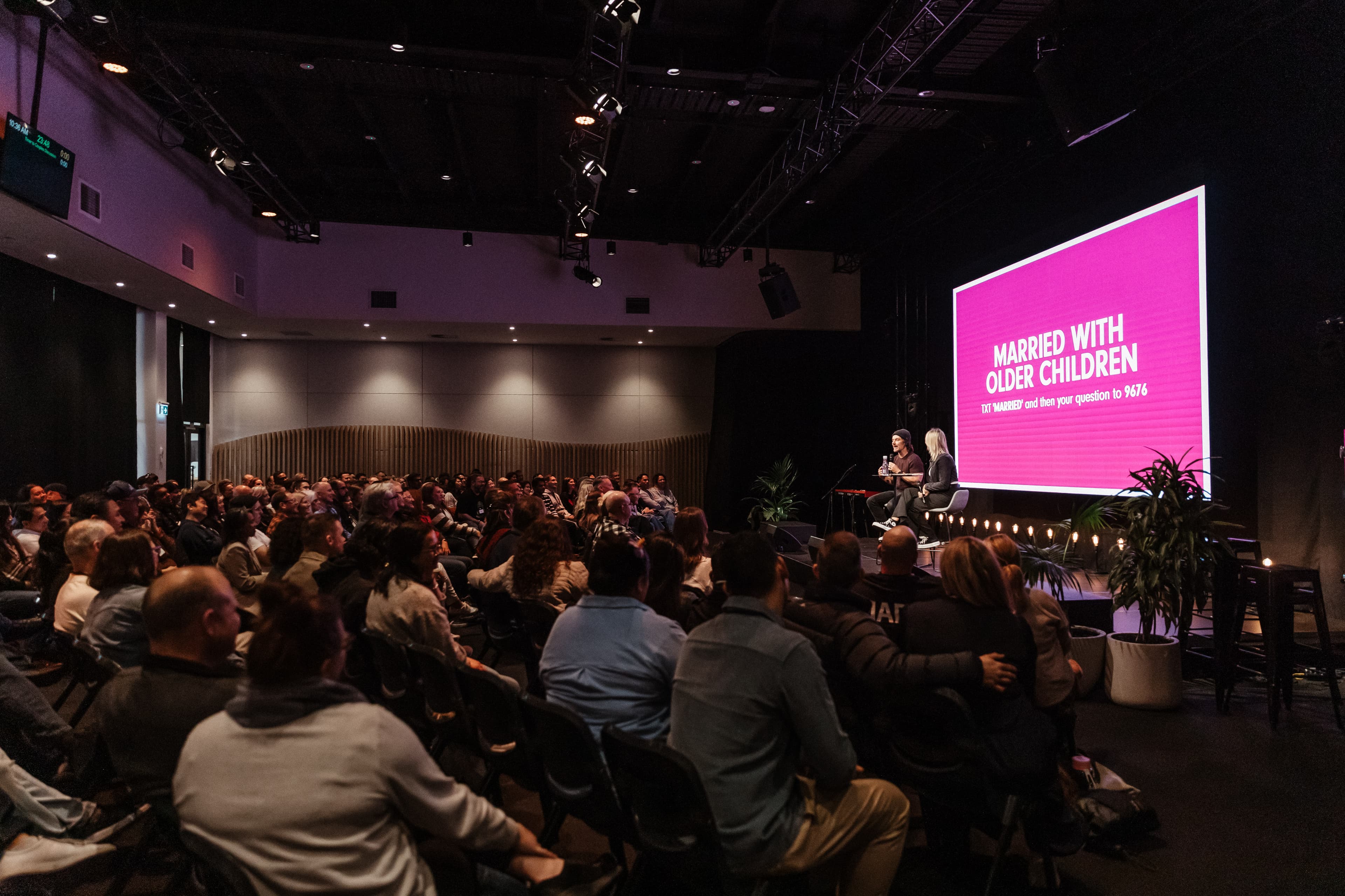 Side of auditorium across the audience in the Married with Young Kids workshop with a speaker on stage
