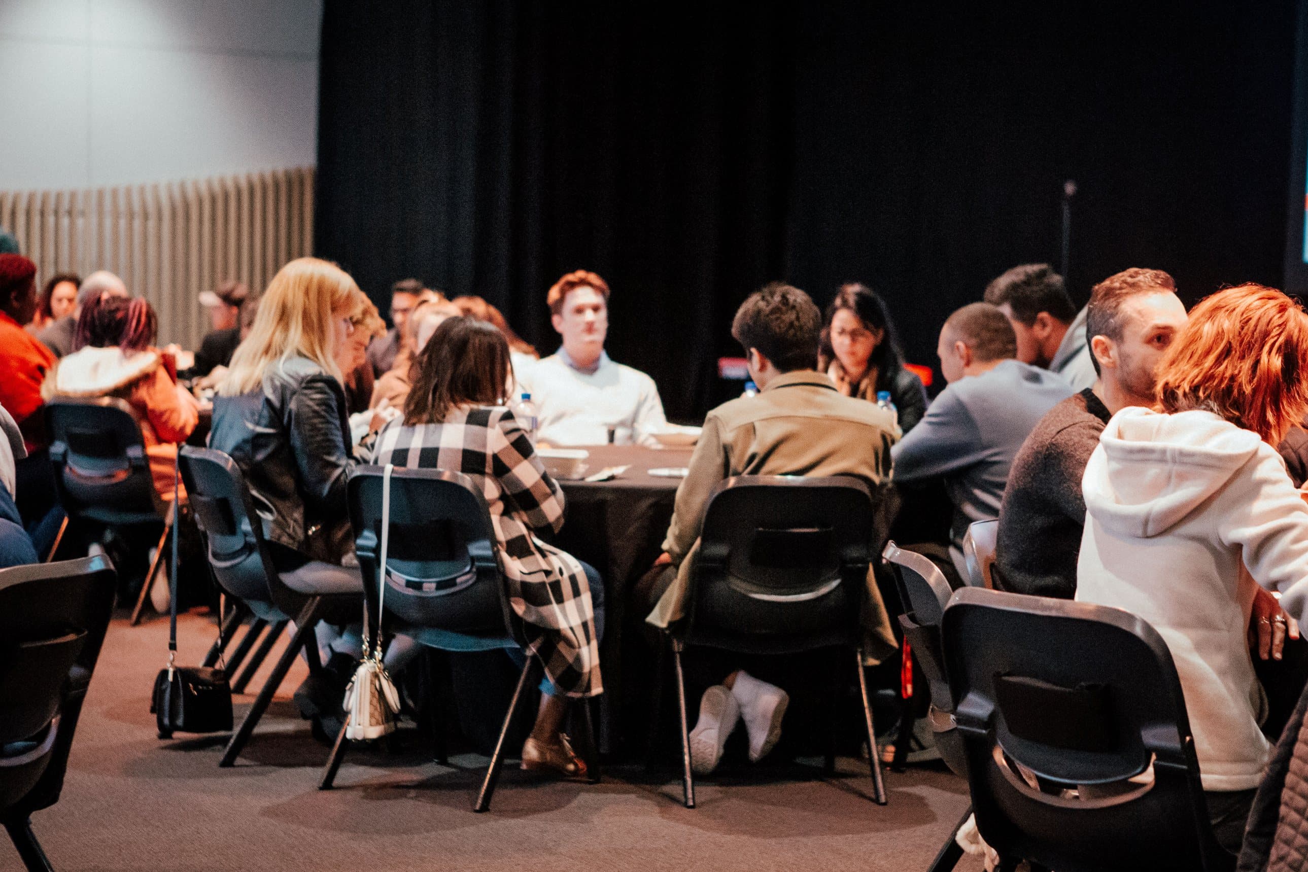 Group of people sitting at a table together in a Night School class talking and learning from each other