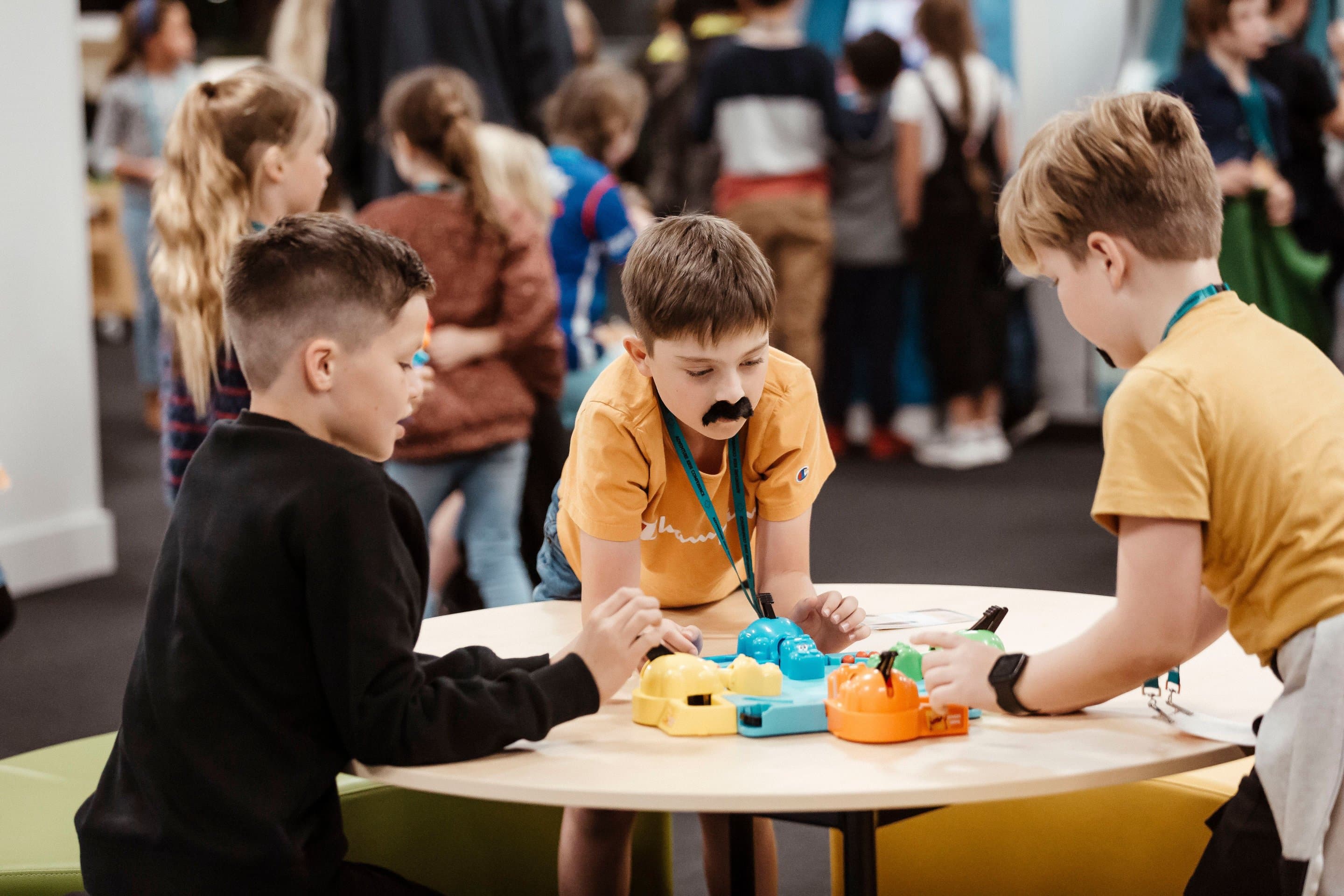 Three boys having fun together playing Hungry Hippo in Adventure Kids