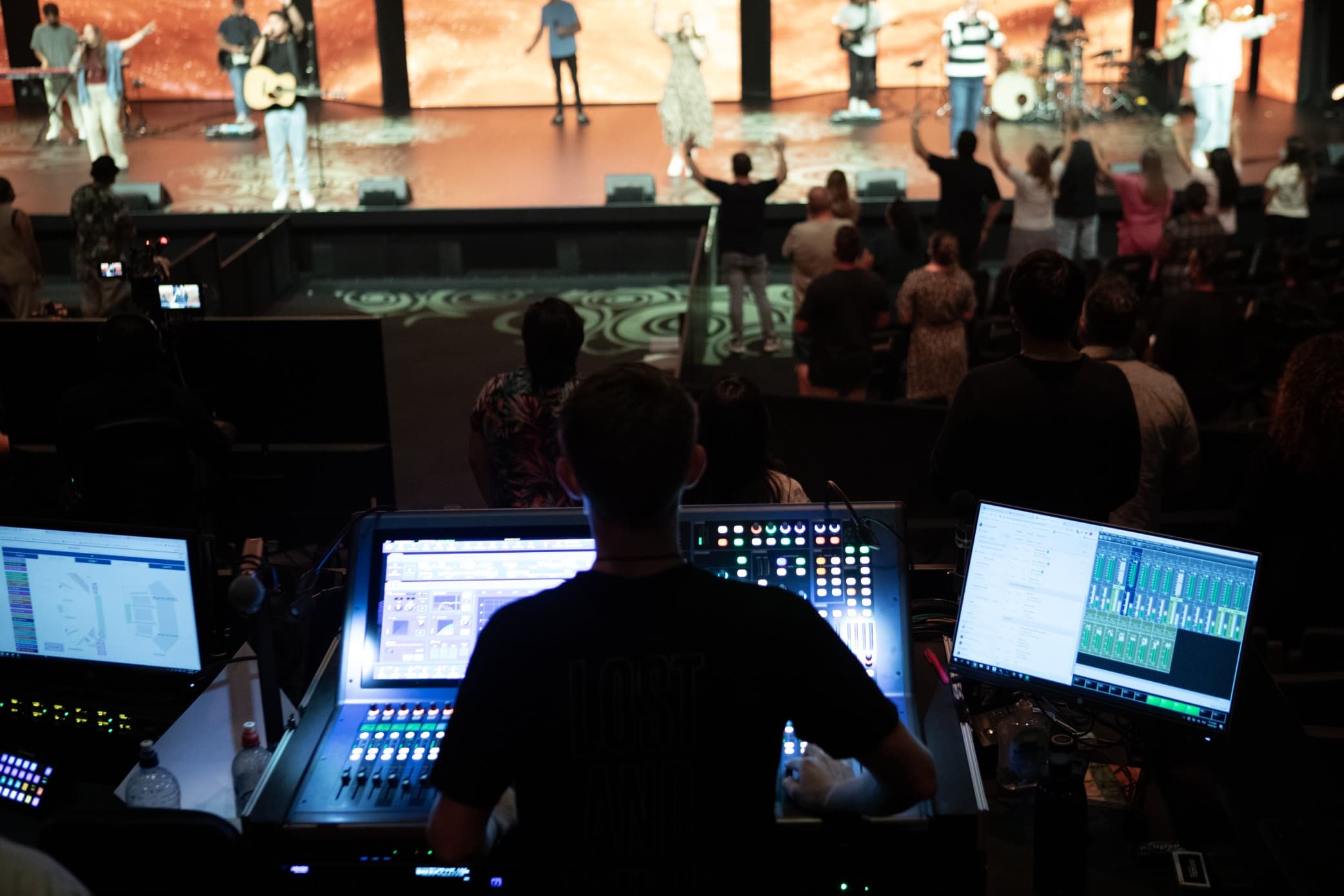 Technical Production - person sitting behind desk, handling sound and lighting for Sunday Service