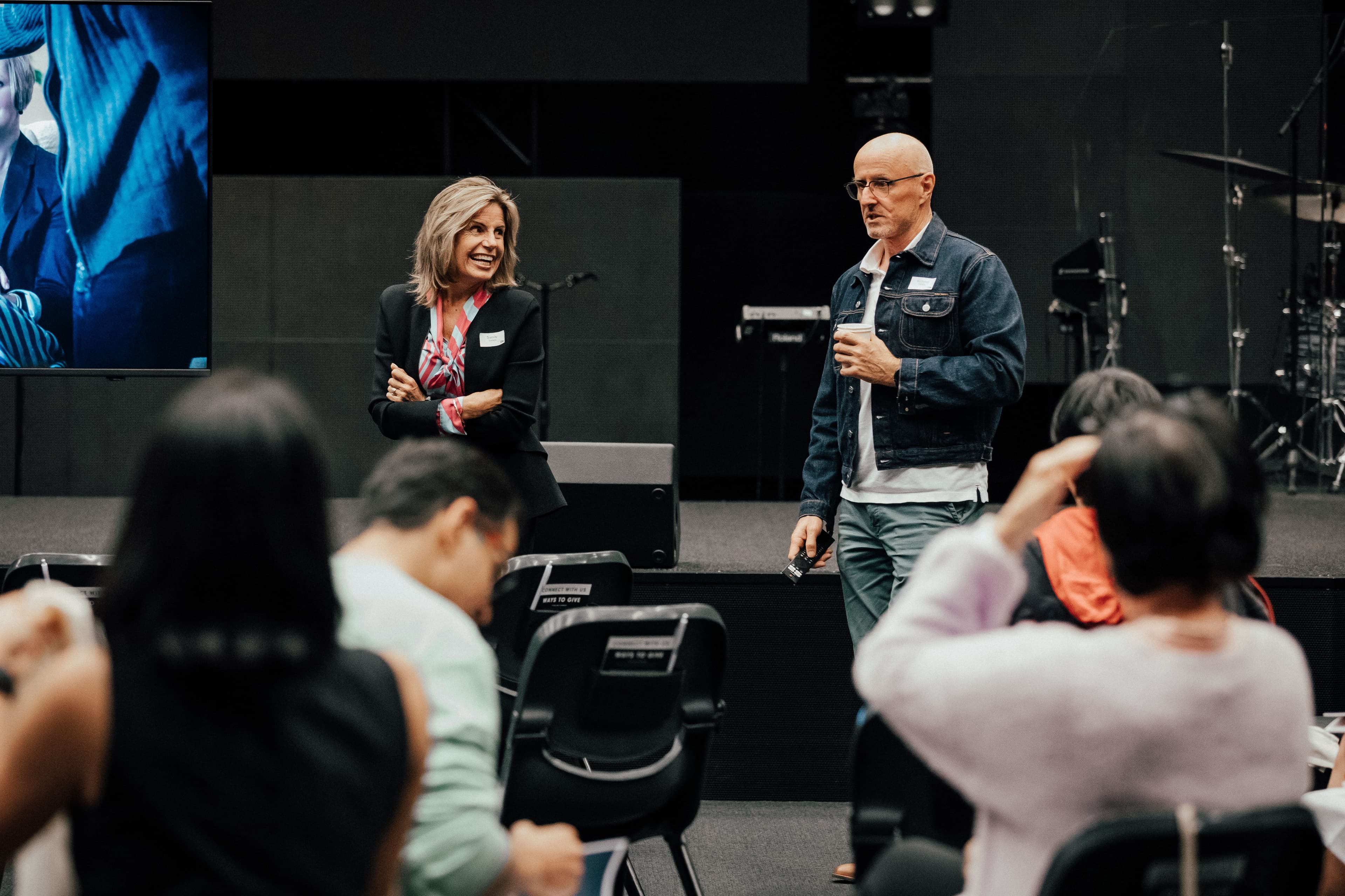 Two facilitators of the Marriage Course standing at the front of the room teaching the course at North Campus