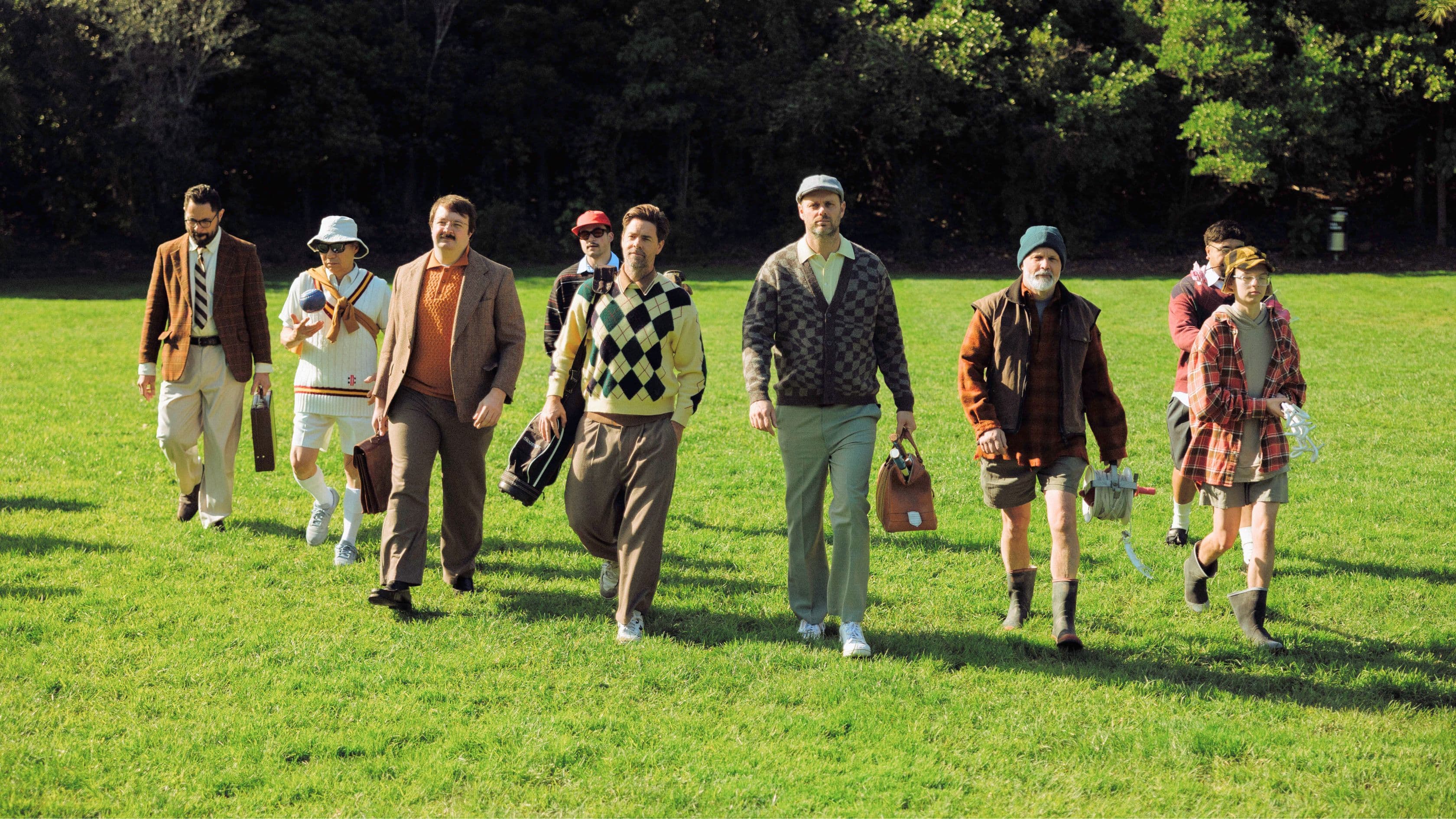 Group of different men walking on a field towards the camera
