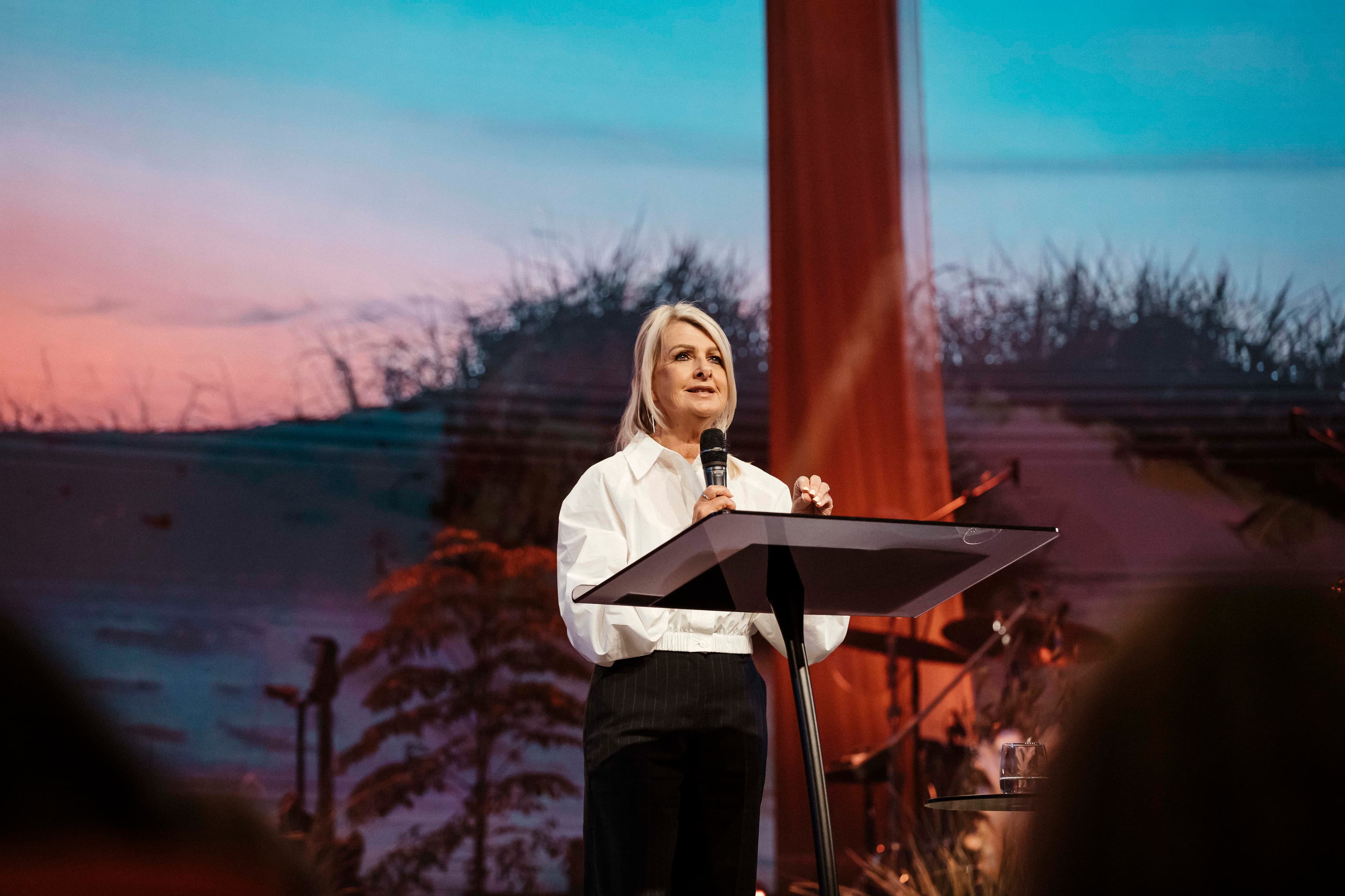 Ps Maree at the pulpit with a microphone in her hand during her message at Sistas