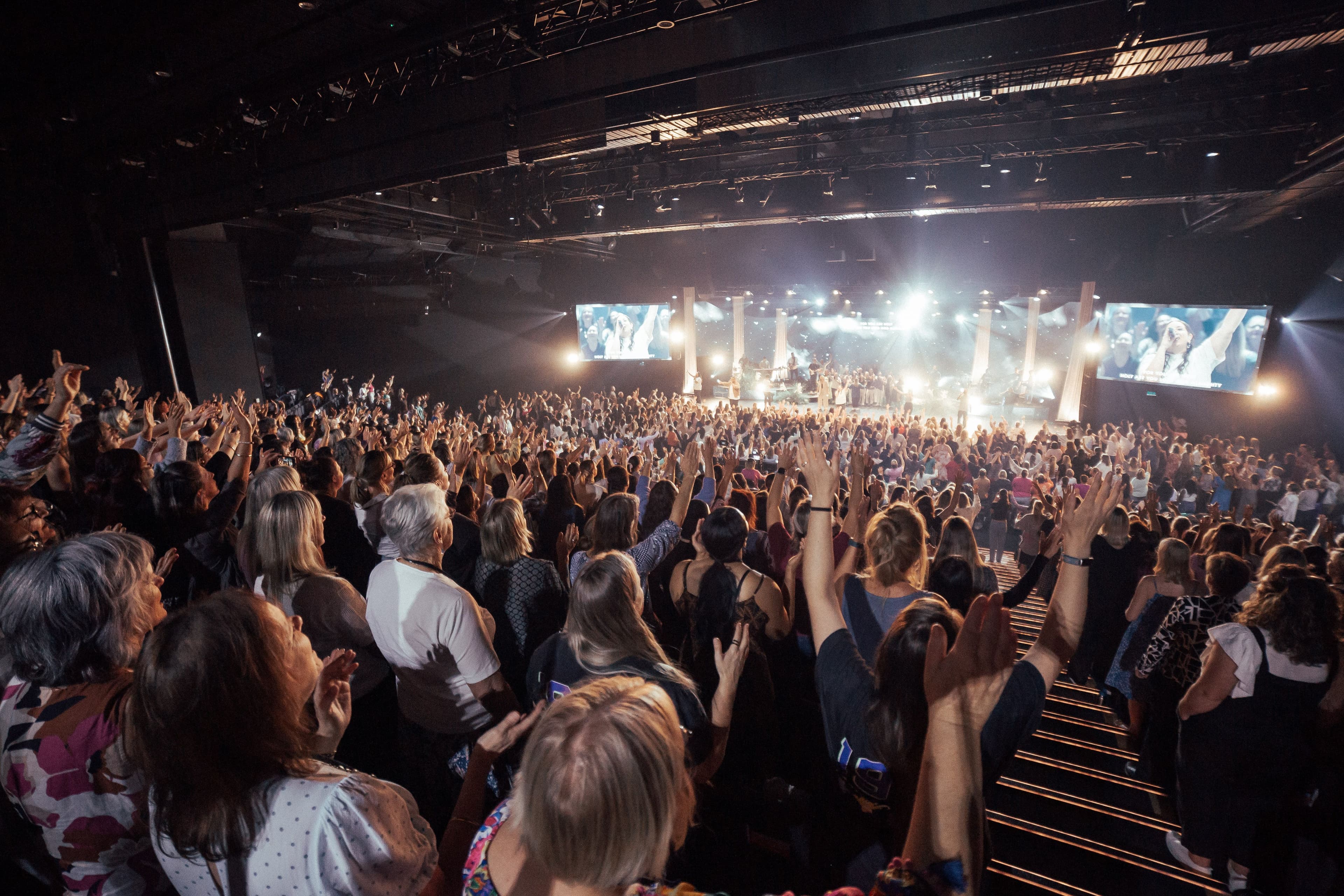 From the back of the auditorium looking to the stage over the room full of women at Sistas Women's Conference