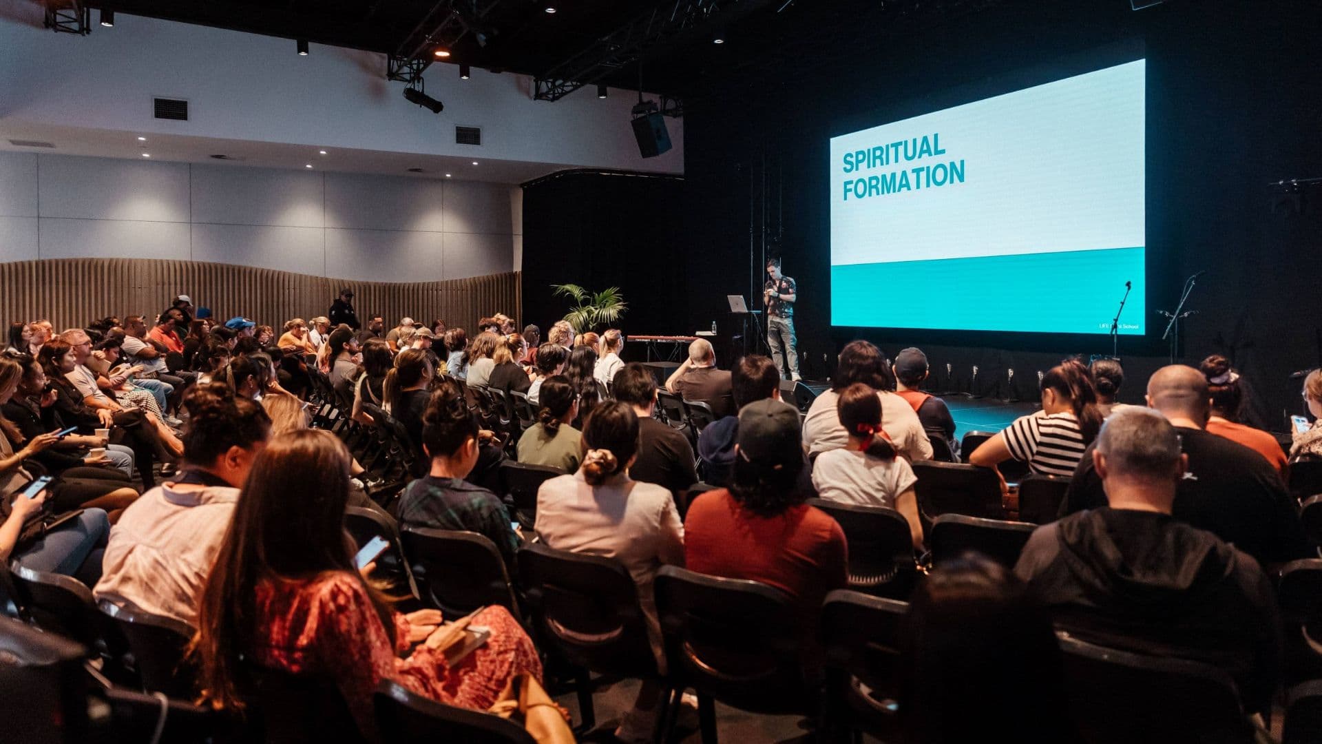 Chapel full of people listening to the Spiritual Formation presenter at Night School at Central Campus